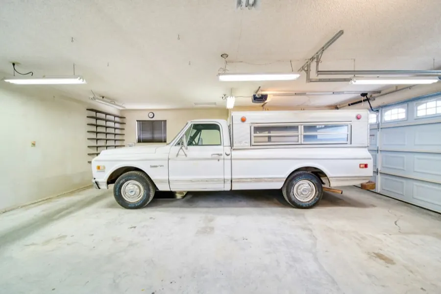 Vintage American pickup parked inside a residential garage with the opener rail visible
