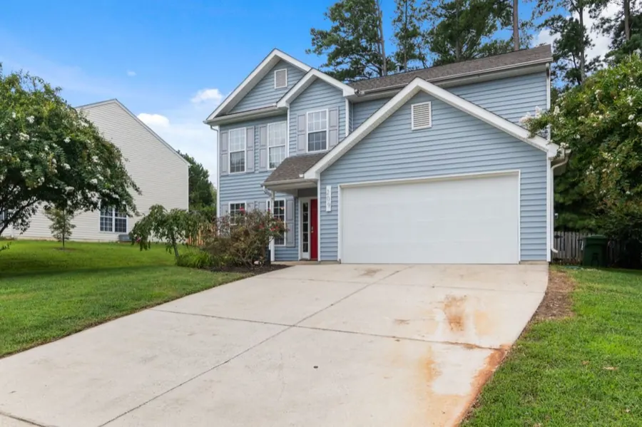 White classic double garage door on a light-blue two-story American home
