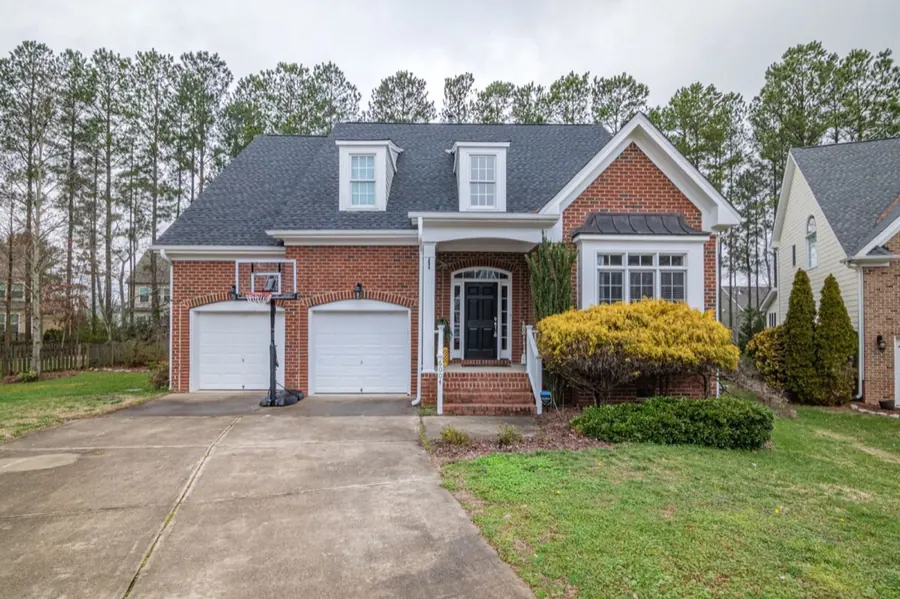 Brick American home with two garage doors and a basketball hoop in the driveway